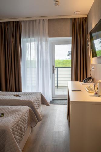 a hotel room with two beds and a desk at Green village Hotel in Mikolaivka