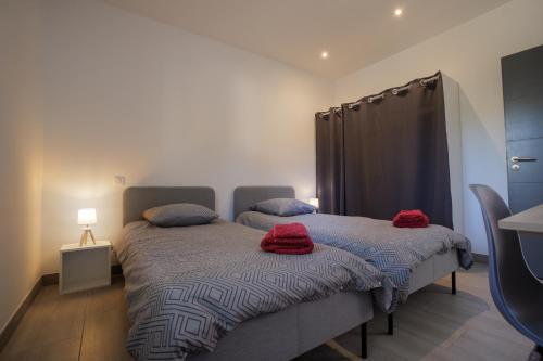 two beds in a bedroom with red towels on them at Casa Léa in Sollacaro
