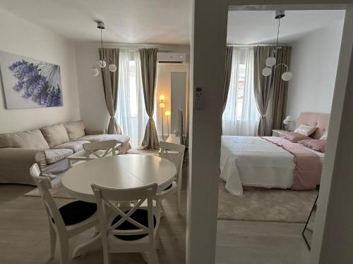 a living room with a bed and a table and a room at Apartman Lavanda in Cres