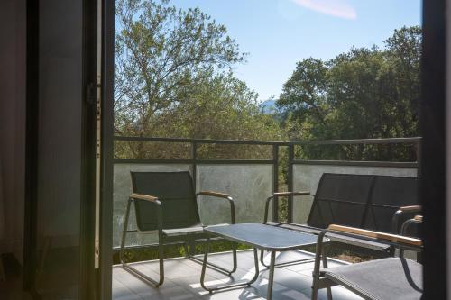 two chairs and a table on a balcony at Casa Léa in Sollacaro