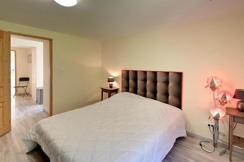 - une chambre avec un grand lit blanc et une tête de lit dans l'établissement Le Kichompré - Appt 50 m² vue montagne, à Gérardmer