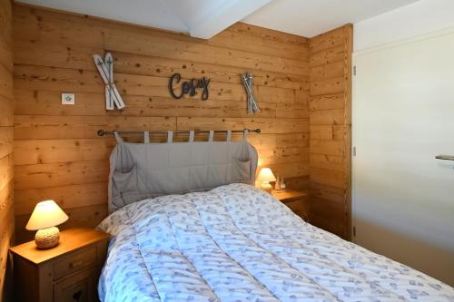 une chambre avec un lit et deux tables de nuit dans l'établissement Les Marmottes - Charmant Appt pour 7 p, à Gérardmer
