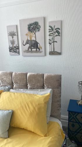 a bedroom with a bed with three pictures on the wall at Right by Leigh Broadway Private Garden large ground fl apt in Southend-on-Sea