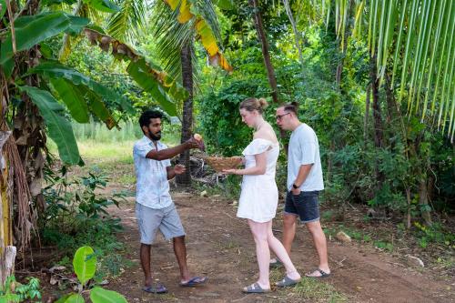 a group of three people standing around a basket at River paradise safari house with cooking class in Udawalawe
