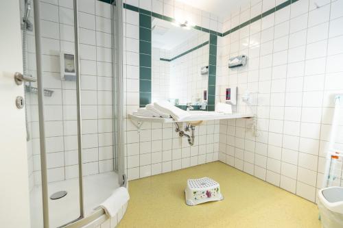 ein Badezimmer mit Dusche, Waschbecken und Spiegel in der Unterkunft Pension Sonnengarten & Therme included - auch am An- & Abreisetag! in Lutzmannsburg