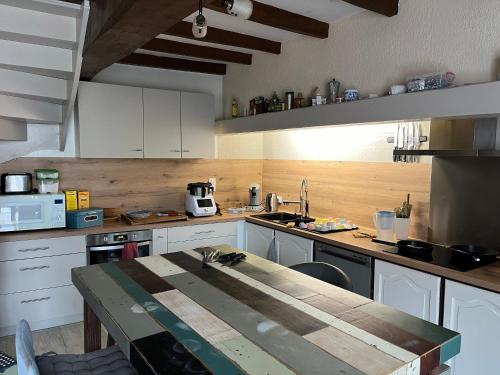 una cucina con tavolo in legno di Chambre chez l'habitant, Au moulin du Bonheur a Le Bourdet