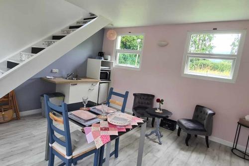 une salle à manger avec une table et des chaises et un escalier dans l'établissement Le gîte des Allains, à Sainte-Suzanne-en-Bauptois
