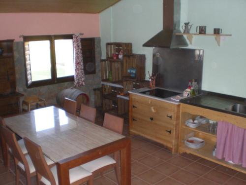 una cucina con tavolo e una sala da pranzo di El Pajar a Castilsabás