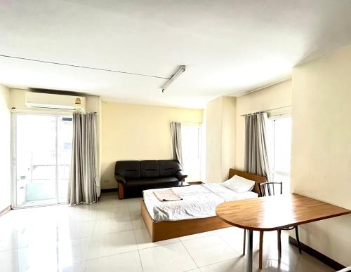 a bedroom with a bed and a table at Good Morning Apartment รังสิต in Ban Bang Khan