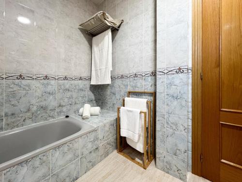 une salle de bain avec une baignoire et un porte-serviettes dans l'établissement VillaHomes, à Villanueva de la Vera