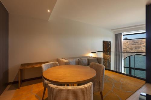 a living room with a table and chairs and a couch at NEYA Porto Hotel in Porto