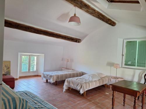 un salon avec deux lits et une table dans l'établissement La Maison Cassée, à Malemort-du-Comtat