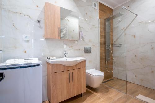 a bathroom with a sink and a toilet and a shower at Anni Seafront Studios in Plati