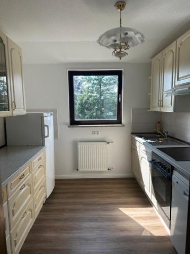 a kitchen with white cabinets and a window at Hotel Pirol in Berlin