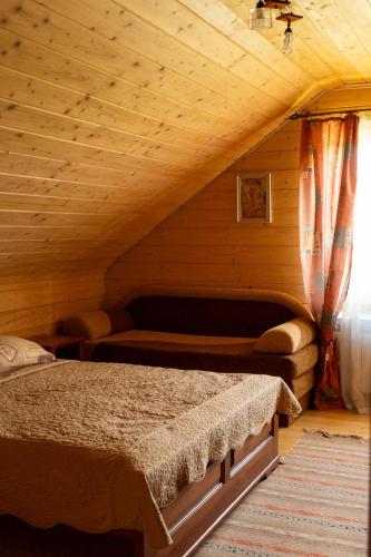 a bedroom with a bed in a wooden attic at Садиба Комфорт in Slavske
