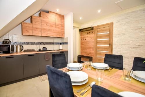 a dining room table with chairs and a kitchen at Domek Pod Brzyzkiem in Białka Tatrzanska
