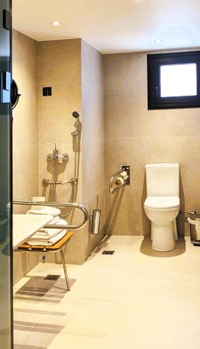 a bathroom with a toilet and a sink at The Port Square Hotel in Piraeus