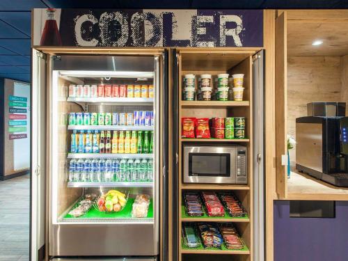 a refrigerator full of food and drinks in a store at ibis budget Beaconsfield in Beaconsfield