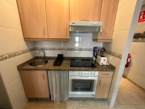 a small kitchen with a sink and a stove at La Luna 2 in Oviedo