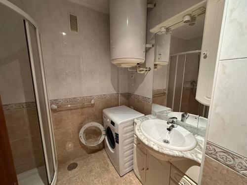 a bathroom with a sink and a washing machine at La Luna 2 in Oviedo