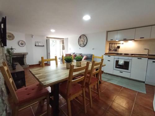 a kitchen and living room with a wooden table and chairs at casa dos Ferreira no Douro in Ucanha