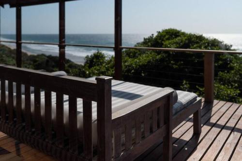 a wooden bench sitting on top of a deck at Aloha 18 in Ponta Mamoli