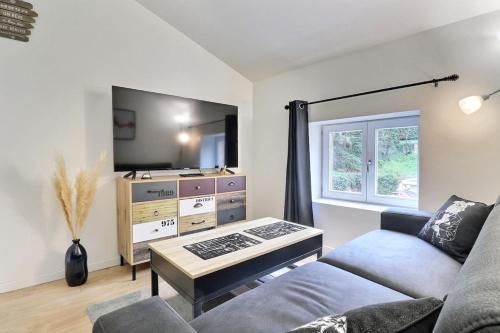 un salon avec un canapé et une télévision dans l'établissement Le St Clair 401 - Luxury equipped apartment - Caluire-et-Cuire, à Caluire-et-Cuire