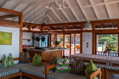 a room with couches and a kitchen with windows at Aloha 18 in Ponta Mamoli