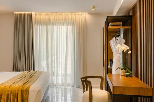 a bedroom with a bed and a dresser and a desk at G Boutique Hotel Kefalonia in Argostoli