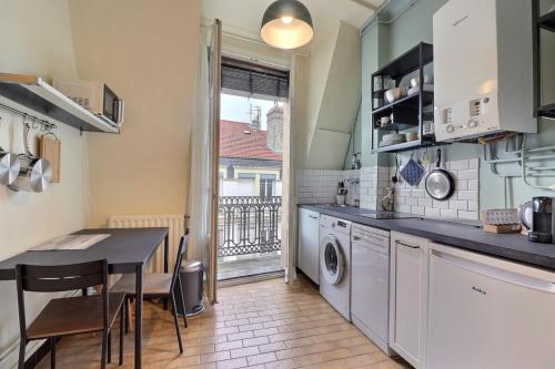 une cuisine avec une table et une machine à laver dans l'établissement Chaponnay - Superb T2 Apartment - Lyon 3rd, à Lyon