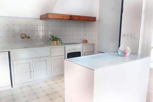 Una cocina con gabinetes blancos y encimera. en Charming house in Sant Pol facing the sea, en Sant Pol de Mar