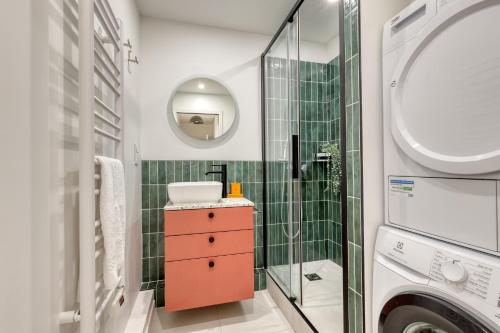 une salle de bain avec un lavabo et une machine à laver dans l'établissement Superb Flat with Balcony - Near Notre-Dame - Paris 05, à Paris