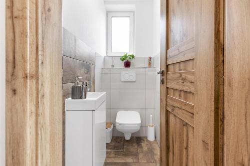 a bathroom with a white toilet and a sink at vila Lešťo in Veľká Lomnica