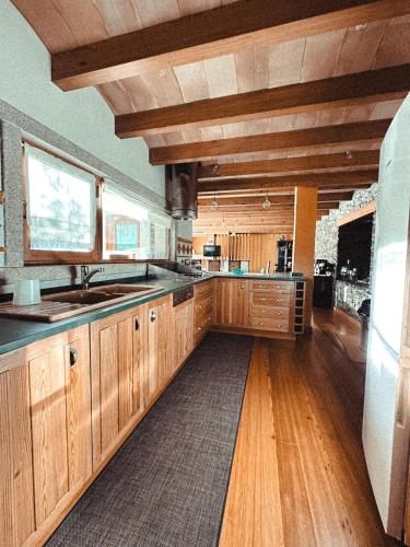 a large kitchen with wooden cabinets and wooden floors at Aguilhões River House in Pedorido