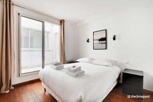 une chambre avec un grand lit blanc et une fenêtre dans l'établissement Charming home Convention Serres, à Paris