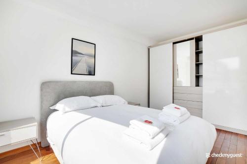 une chambre avec un lit blanc avec des serviettes dessus dans l'établissement Charming home Convention Serres, à Paris