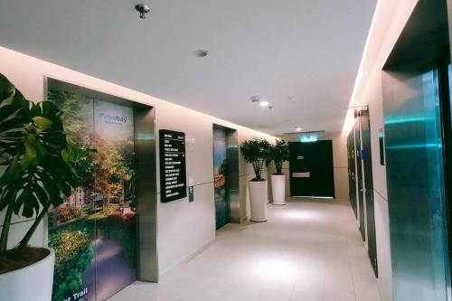 a hallway with potted plants in a building at Maya Bay Residences Gamuda Cove SplashMania in Pulau Kempas