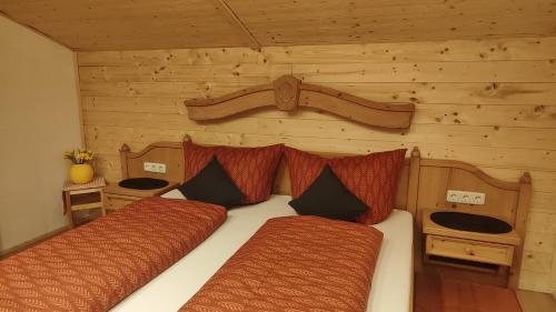 バッハにあるFerienhaus Lechtaler Alpenの丸太小屋のベッドが2つある寝室