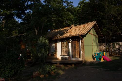a small small house with a porch in a yard at Abrigo Cipó in Serra do Cipo