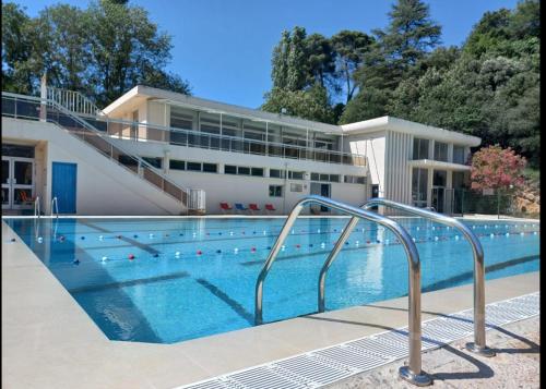 une piscine devant un immeuble dans l'établissement La pinède de Manon Chambre et table d'hôtes, à Barjols