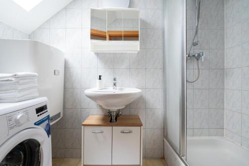 a bathroom with a sink and a washing machine at FarawayHomes Studio Graz #6 in Graz