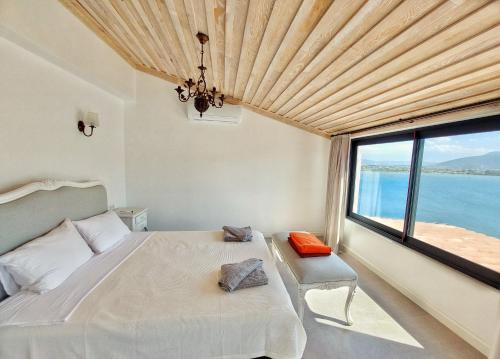 a bedroom with a bed and a large window at Ece Hotel Sovalye Island in Fethiye