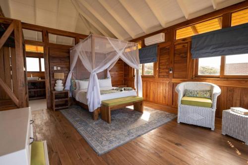 a bedroom with a canopy bed in a room at Aloha 19 in Ponta Mamoli