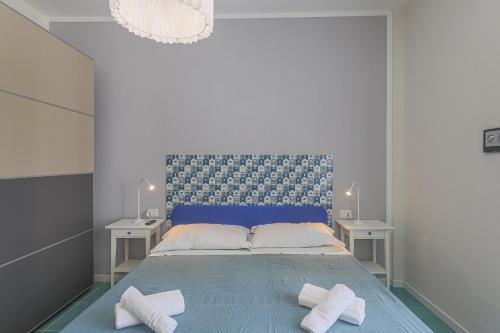 een slaapkamer met een blauw bed en 2 witte handdoeken bij Amami Home in Salerno