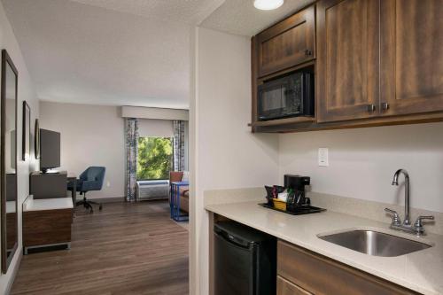 a kitchen with a sink and a living room at Hampton Inn Northwood in Myrtle Beach