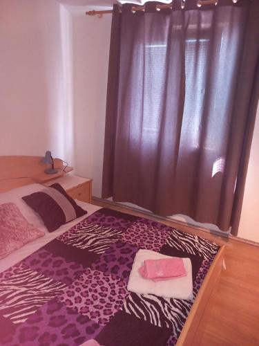 a bedroom with a bed with a purple rug at Apartments Jerica in Bol