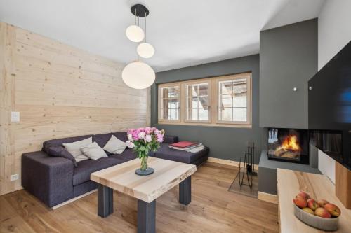 a living room with a couch and a fireplace at Chalet Larchwood by Mrs Miggins in Grimentz