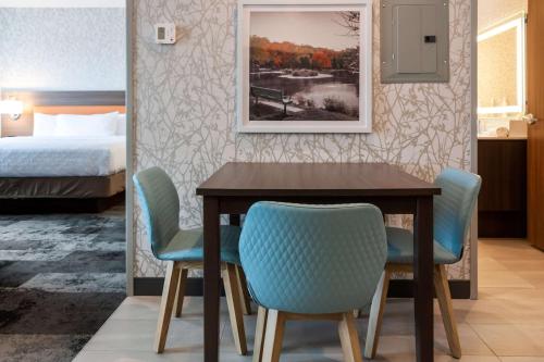 a dining room with a table and chairs and a bed at Home2 Suites By Hilton Bolingbrook Chicago in Bolingbrook