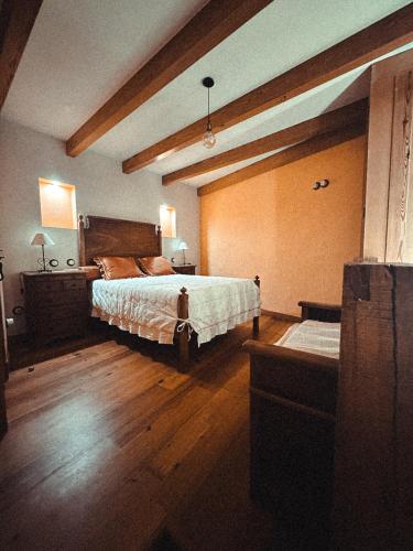 a bedroom with a large bed and wooden floors at Aguilhões River House in Pedorido