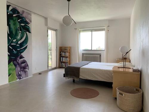 une chambre avec un lit et un tableau au mur dans l'établissement Grande villa californienne calme près de la mer, au Golfe-Juan